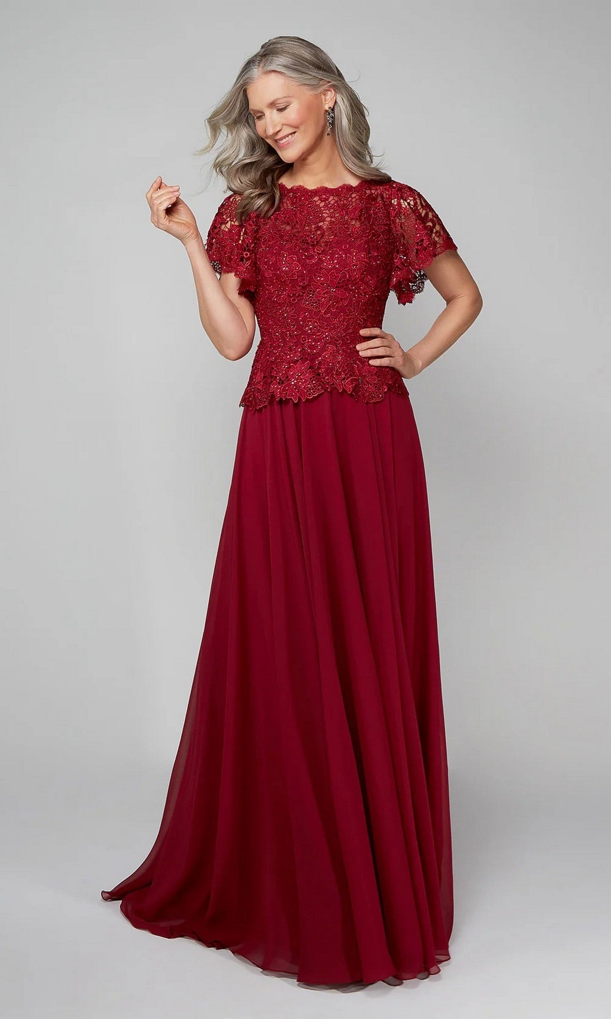 Model wearing the Alyce 27469 long formal dress, featuring short sleeves and a burgundy lace-embroidered bodice, posing and smiling against a plain light background.